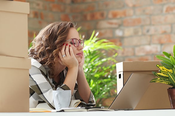 Bored woman wearing glasses sitting at a desk