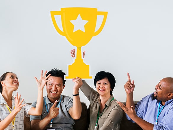 Coworkers celebrating their success with trophy