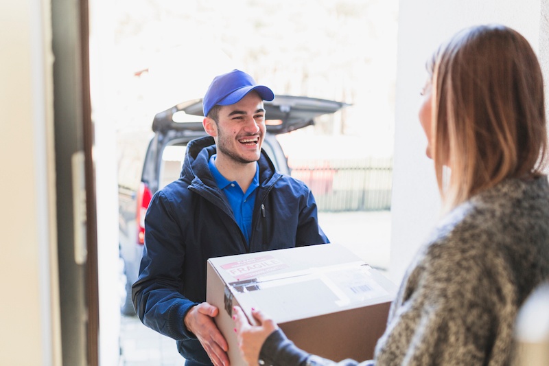 Cheerful man delivering parcel to client