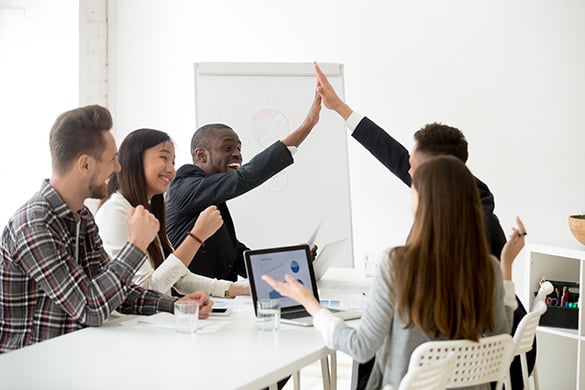 Group of young coworkers celebrating achieving a goal